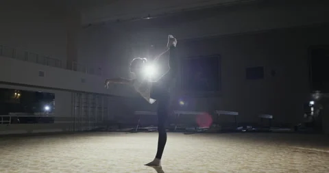 Side view of flexible young female gymnast performing standing split while Stock Footage 138530983