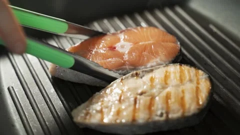 Side View Flipping Grilled Salmon on Iron Pan Stock Footage 149025841