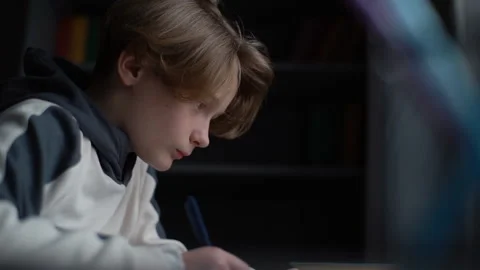 Side view of focused child little boy kid writing to notebook with pen looking Stock Footage 151243455