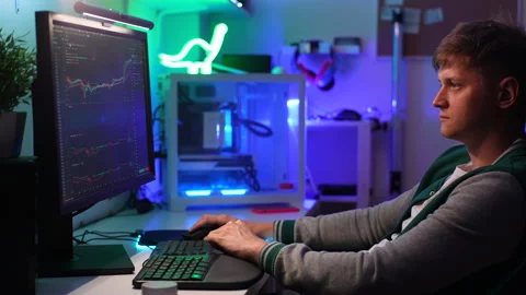 Side view of focused financial analyst male using computer with display showing Stock Footage 247922290