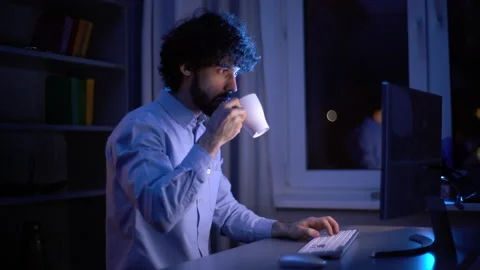 Side view of focused freelancer working on computer and drinking coffee from cup Stock Footage 146417131