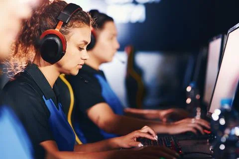 Side view of a focused mixed race girl, female cybersport gamer wearing Stock Photos