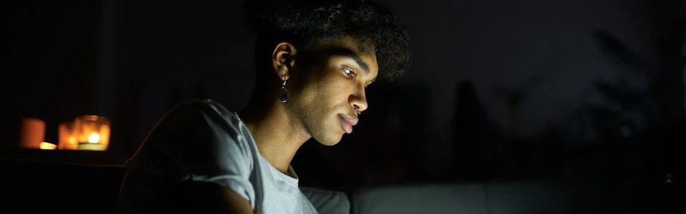 Side view of focused young guy reading e book or watching video using tablet pc Foto stock