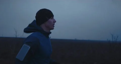 Side view follow up shot of young athlete man running fast along empty fields Видео 148331518