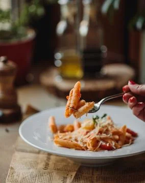 Side view of fork with pasta with tomato sauce and parmesan cheese Stock Photos