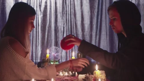 Side view of fortune teller man tied red rope on woman's hand Stock Footage 143514437