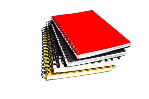 Side view of four different color covered paper note books gathered on top of Stock Photos