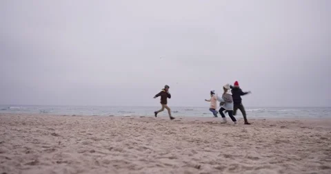 Side view of four friends running after each other during a fun game of tag on Stock Footage 308314573