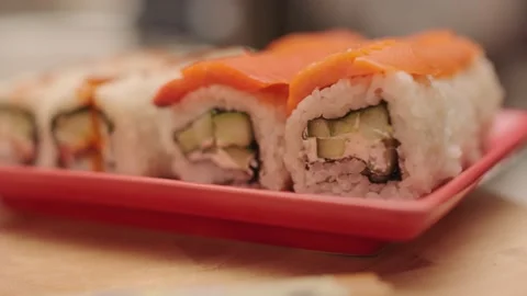 Side view of four slices of sliced Japanese Maki sushi roll with rice, salmon Stock Footage 140797220
