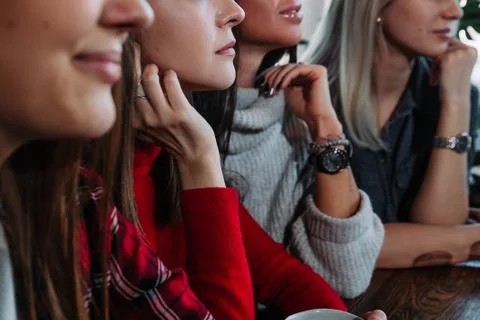 Side view of a Four smiling friends sitting by the table in cafe Stock Photos