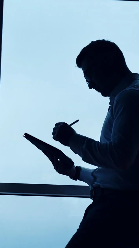 Side view of a freelancer sitting on the desk. Man in glasses uses stylus pencil Stock Footage 325040529