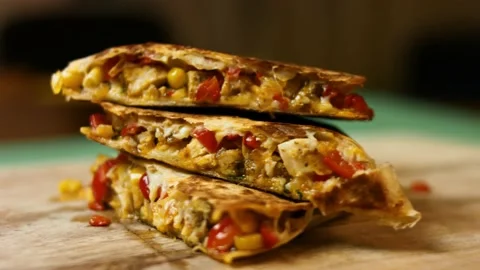 Side view of freshly fried hot chicken quesadilla on a wooden cutting board Stock Footage 151295036