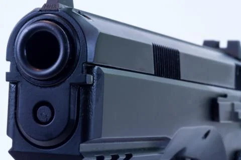 Side view of a full-size pistol with a barrel opening at the front. Stock Photos