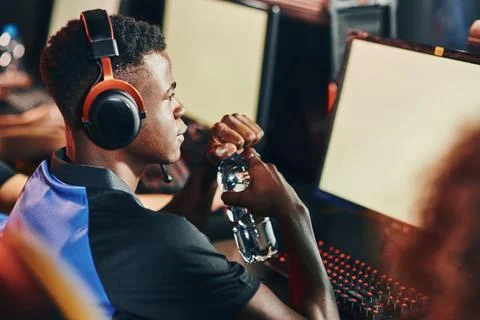 Side view of a fully concentrated professional african cybersport gamer wearing Stock Photos