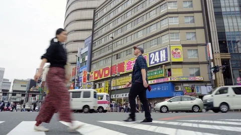 Side View Gimbal Tracking Shot of Caucasian Man Crossing Street in Busy Japanese Stock Footage 105058809