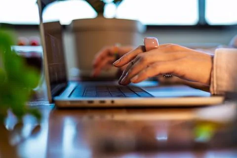 Side view of a girl's hand using a laptop. close-up of a young woman's hand.. Stock Photos