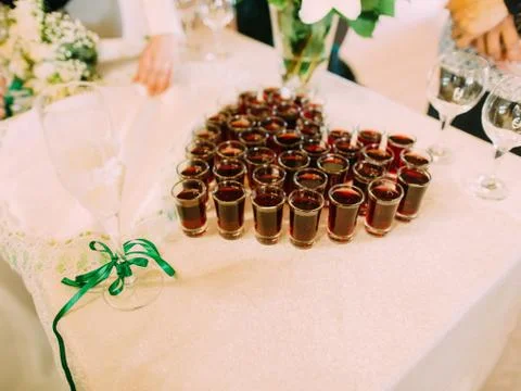 The side view of the glasses with whiskey placed in the form of the heart. Stock Photos