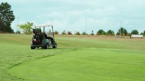 Side view of a golf cart parked on a golf course Stock Footage 217956054