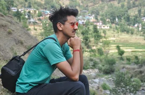Side view of a good looking guy wearing sunglass and carrying camera bag  Foto stock