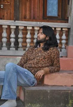 Side view of a good looking Indian young guy with long hair style Stock Photos