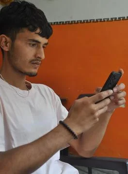 Side view of a good looking young men using phone while sitting indoors Stock Photos