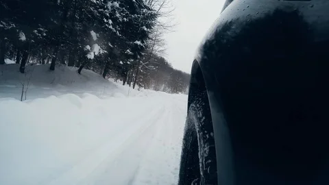 A side view gopro shot of a car on a mountain road winter snow Stock Footage 86704715