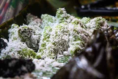 Side View of Green Triangular Lupis Coated in Shredded Coconut Served on Ba.. Stock-Fotos