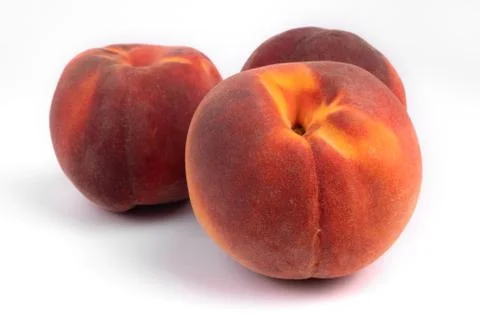 Side view of a group of three organic big peaches laying on white background Stock Photos