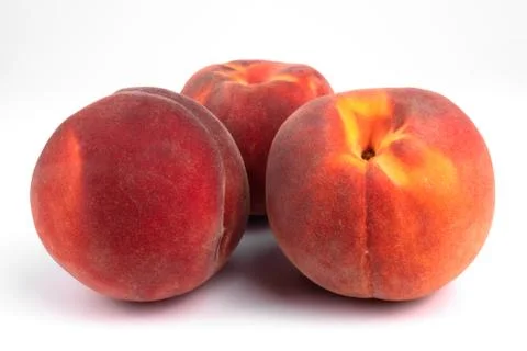 Side view of a group of three riped peaches laying on white background 库存照片