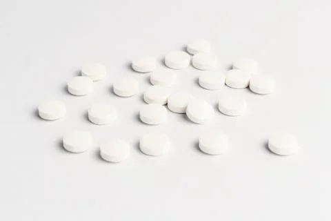 Side view of a group of white pills on white background, in random order Stock Photos
