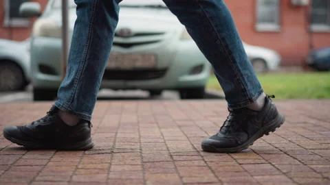 Side View Guy Wearing Black Winter Coat And Jeans Walking Tiled Urban Walkway Stock-Footage 310514485