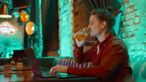 Side view of a guy working on a laptop in a cafe. Stock Footage 231727598