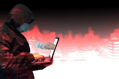 Side view on hacker in black hoody with laptop at blurry city  background. Stock Photos