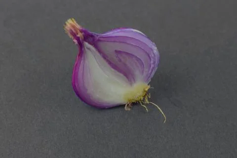 Side view of a half peeled pink colored onion isolated before a black backgro Stock Photos