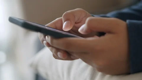 Side view. Hand of girl using smartphone in the living room at home Stock Footage 126370156