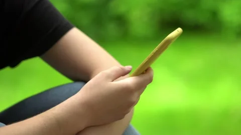 Side view. Hand of girl using smartphone, typing message. Close-up of young Stock Footage 131530248