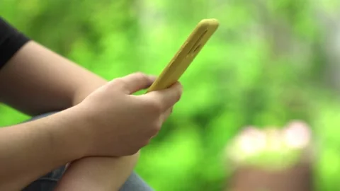 Side view. Hand of girl using smartphone, typing message. Close-up of young Stock Footage 132158876