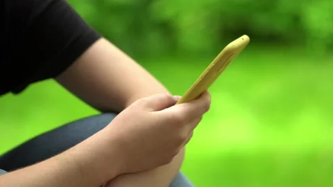 Side view. Hand of girl using smartphone, typing message. Close-up of young Stock Footage 132187726