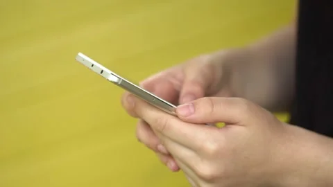 Side view. Hand of girl using smartphone, typing message. Close-up of young Stock Footage 132335905