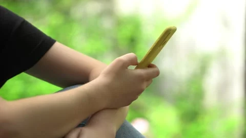 Side view. Hand of girl using smartphone, typing message. Close-up of young Stock Footage 132373029