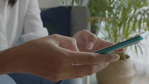 Side view. Hand of girl using smartphone in the living room at home Stock Footage 141442700