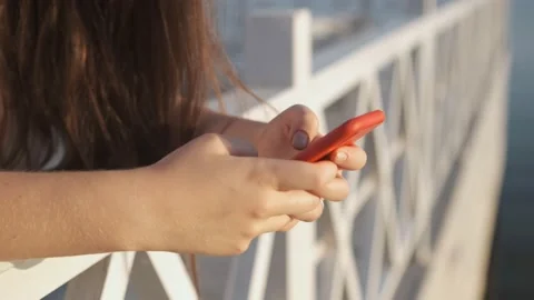 Side view. Hand of girl using smartphone on the terrace by the lake, typing Stock Footage 159414814