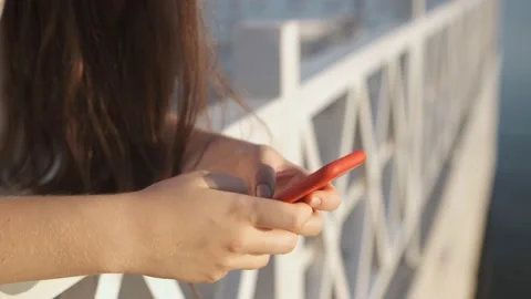 Side view. Hand of girl using smartphone on the terrace by the lake, typing Stock Footage 159498681