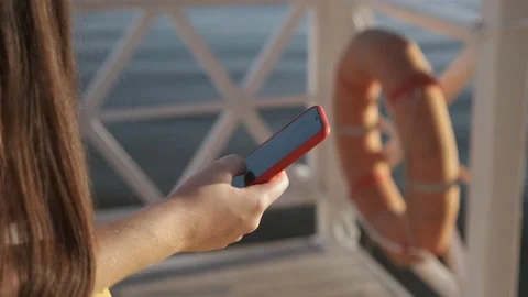 Side view. Hand of girl using smartphone on the terrace by the lake, typing Stock Footage 159543102