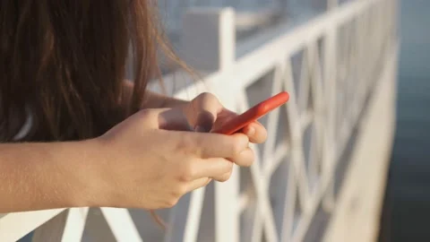 Side view. Hand of girl using smartphone on the terrace by the lake, typing Stock Footage 159572882