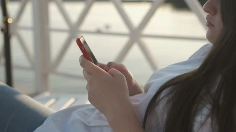 Side view. Hand of girl using smartphone on the terrace by the lake, typing Stock Footage 159659479