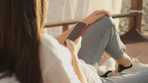 Side view. Hand of girl using smartphone on the terrace by the lake, typing Stock Footage 159659853