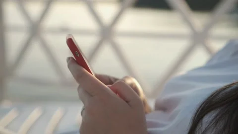 Side view. Hand of girl using smartphone on the terrace by the lake, typing 스톡 동영상 159734365