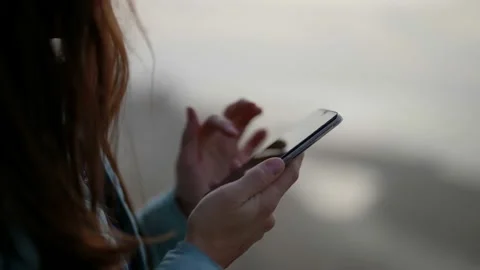 Side view the hand of a girl using a smartphone on the street in the evening Video stock 166167267