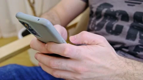Side view. Hand of man using smartphone in the living room at home, typing Video stock 231757901